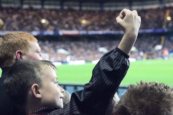 Young boy holding up his hand, doing the wanker sign, meaning of hand signs