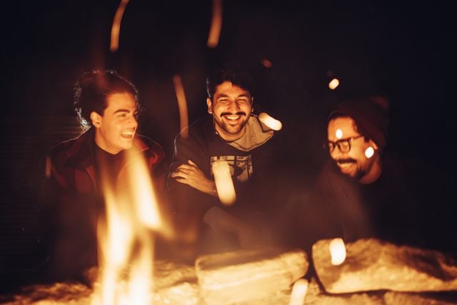 A group of friends sharing stories in Portuguese at a campsite
