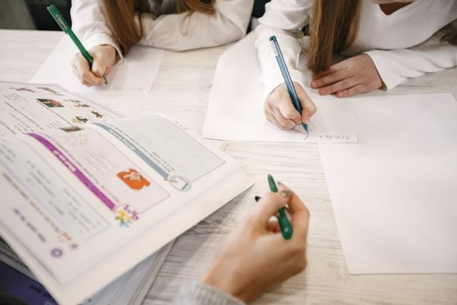 Portuguese learners completing grammar exercises together, illustrating agreement between nouns, adjectives, and articles.