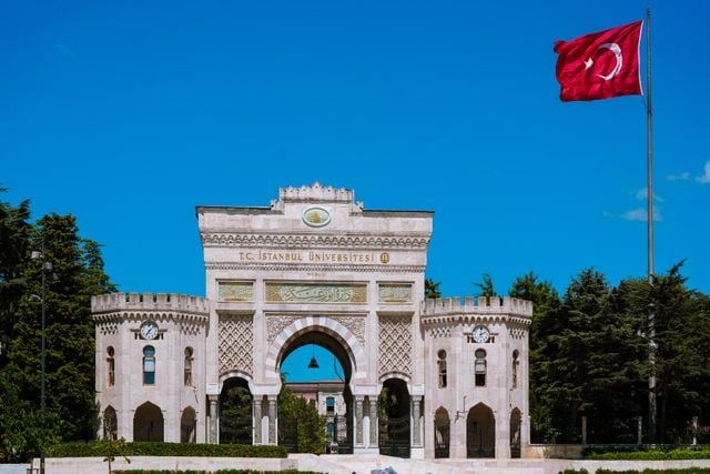 Entrance to Istanbul University with the Turkish flag flying above the historic gate.