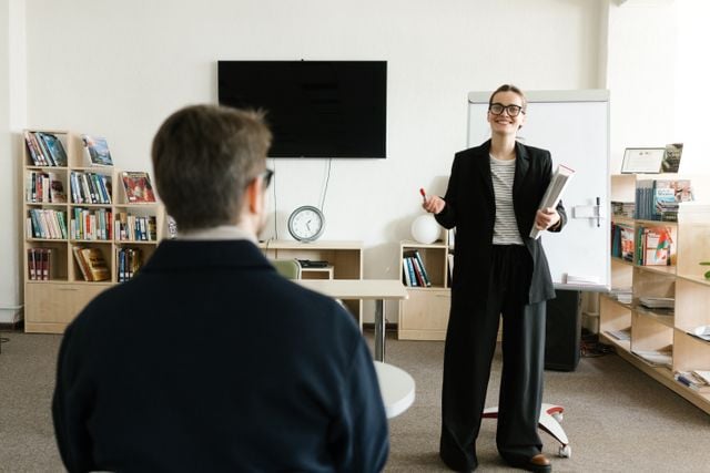 Professional language trainer teaching a one-to-one lesson focused on workplace communication and career development.